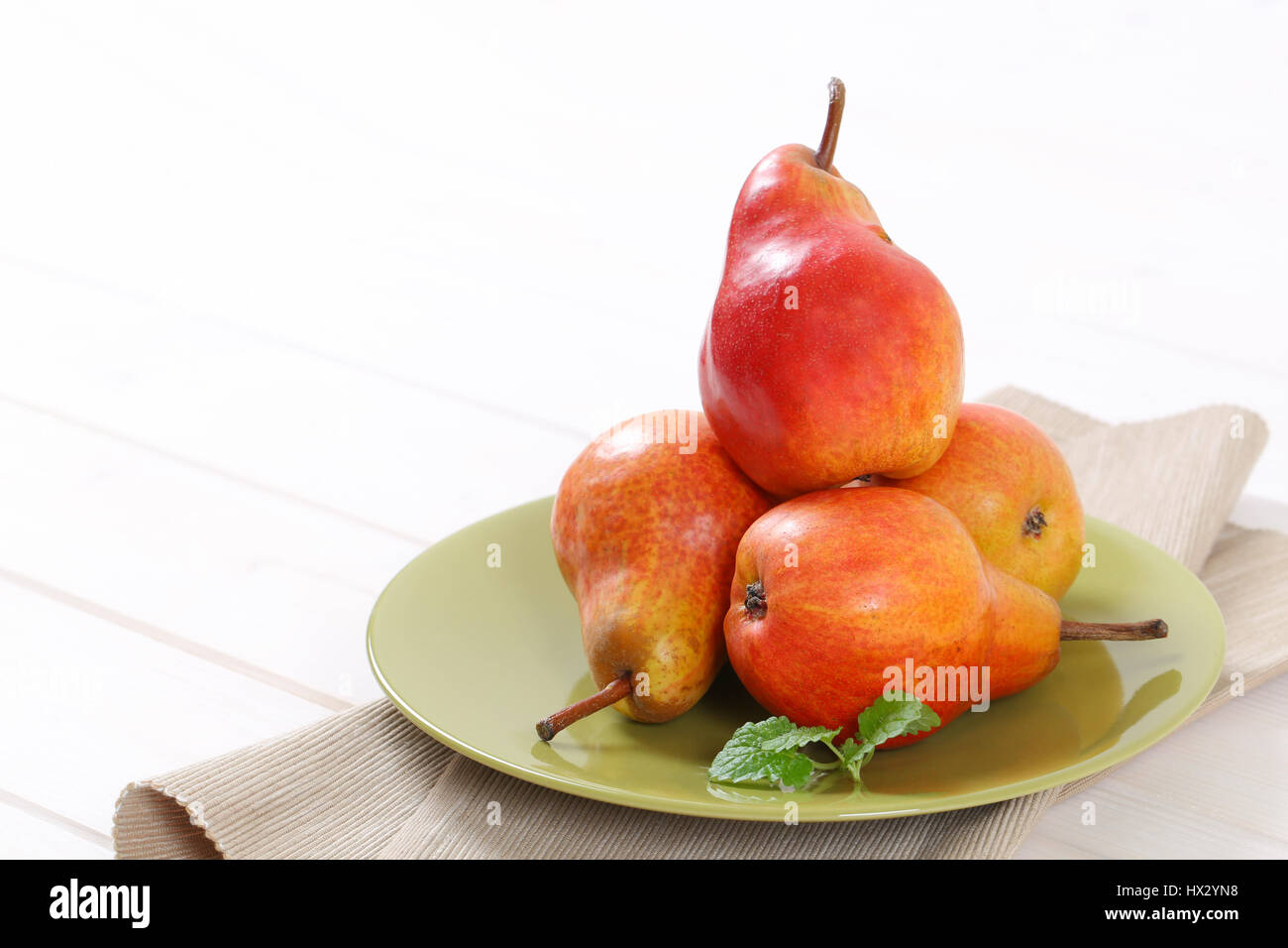 plate of ripe red pears on white background - close up Stock Photo