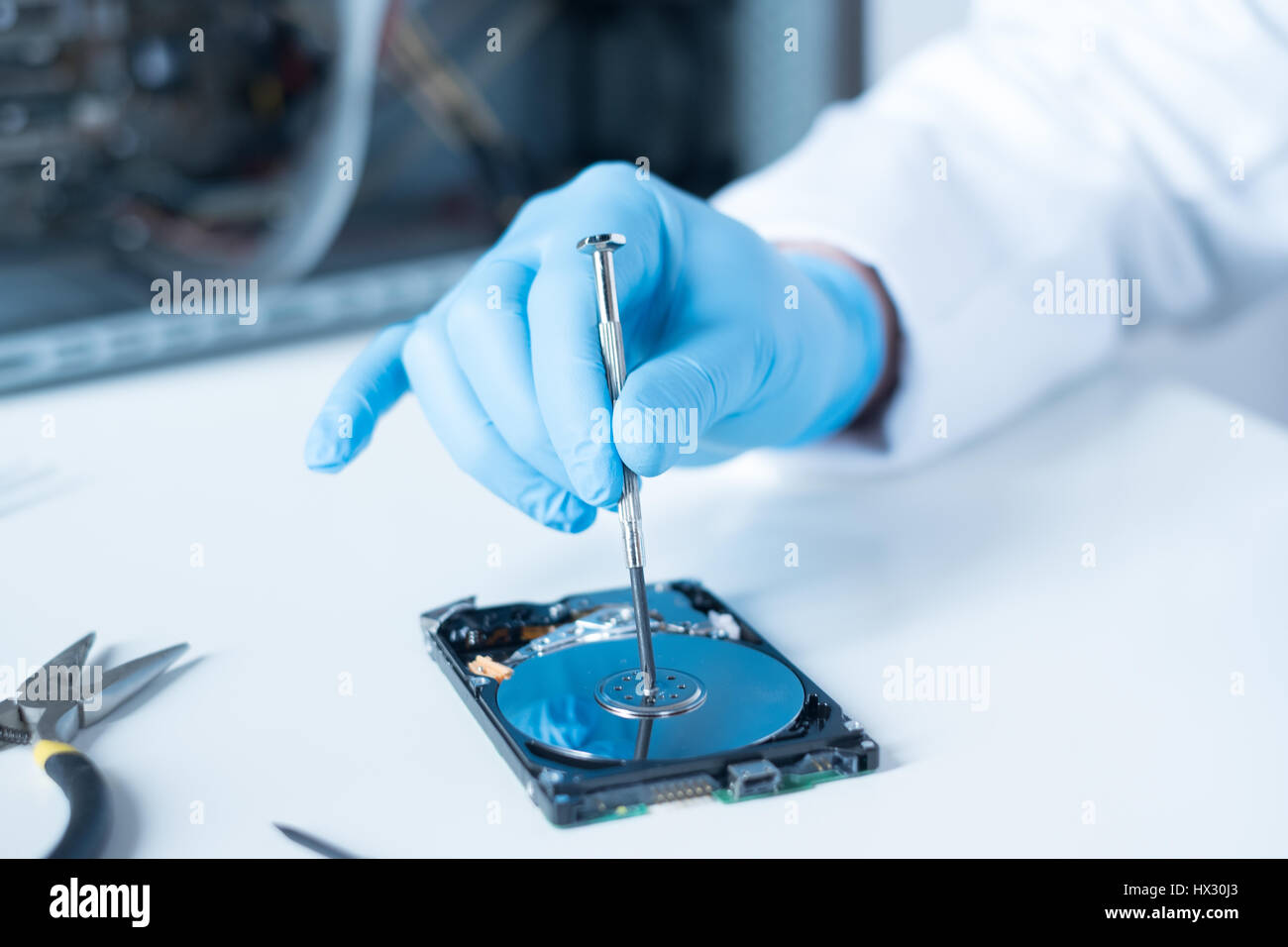 Lab engineer repairing and fixing broken hard disk for data recovery Stock Photo