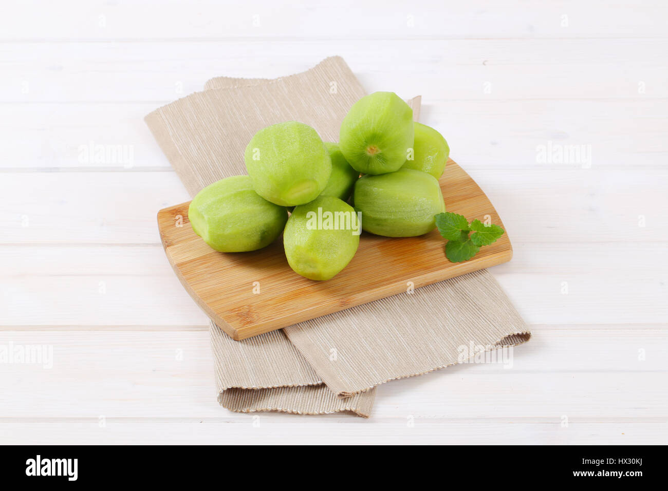 pile of peeled kiwi on wooden cutting board Stock Photo