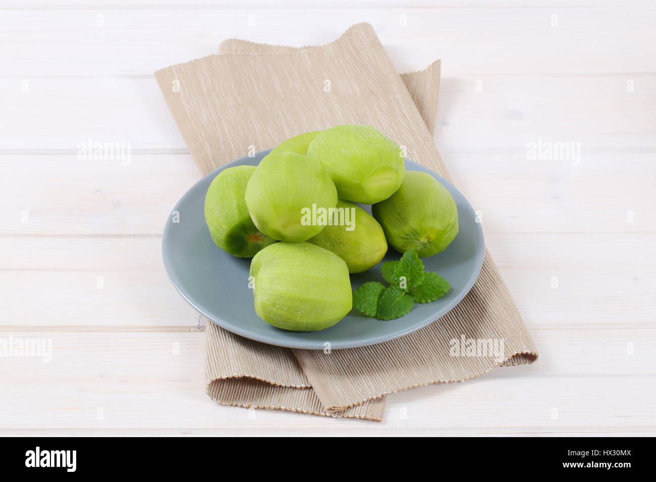 plate of peeled kiwi on beige place mat Stock Photo