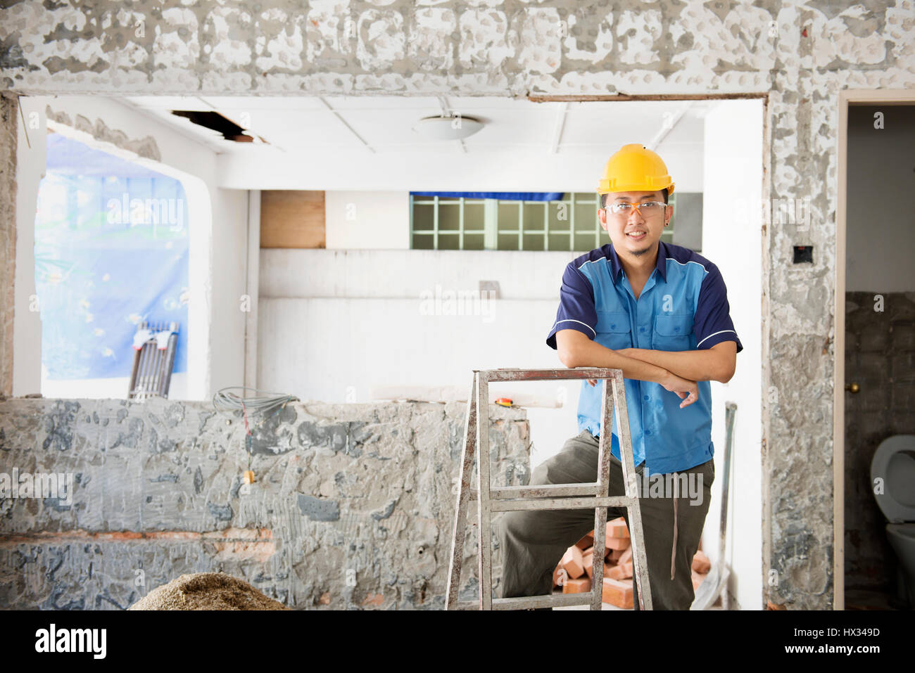House renewal concept. Asian construction worker smiling and looking at
