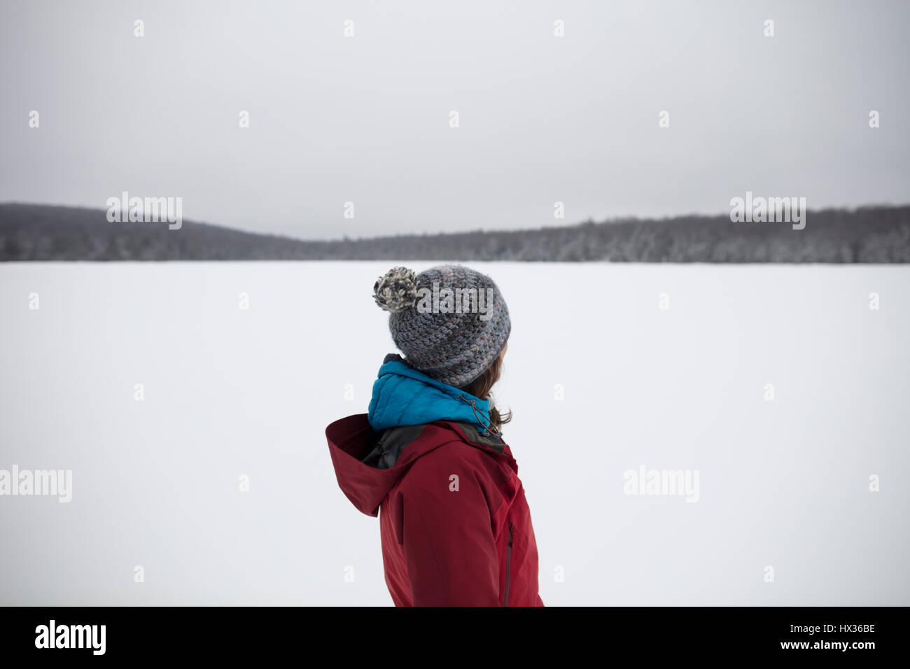 A lady in a red jacket snowshoes after a snow storm in Hastings Highlands, Ontario, Canada. Stock Photo