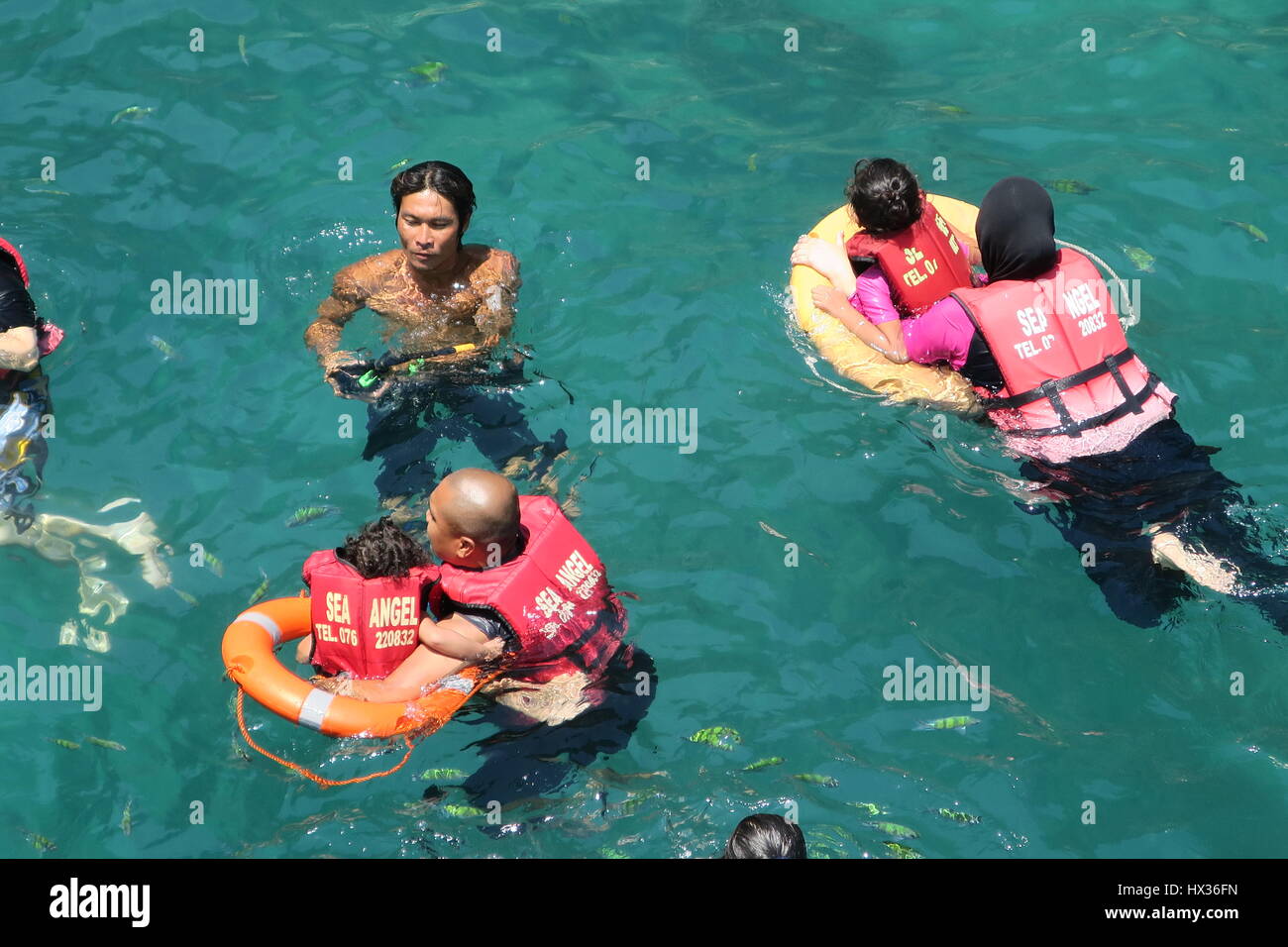 Swimmers with life jackets and life vests are swimming and enjoying in