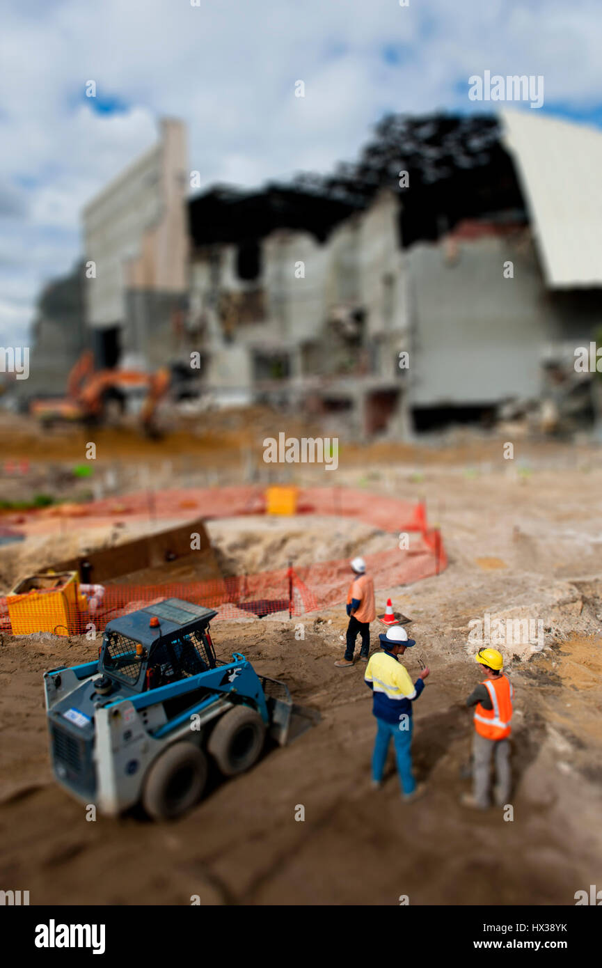 construction workers and equipment on demolition site, with tilt shift effect. Stock Photo