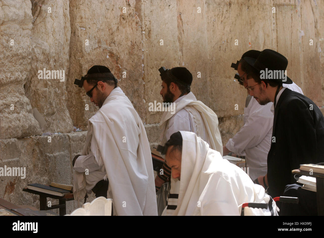 Jewish men pray at the western wall in Jerusalem, IL. The wall is one of the holiest sites in Judaism attracting thousands of worshipers daily Stock Photo