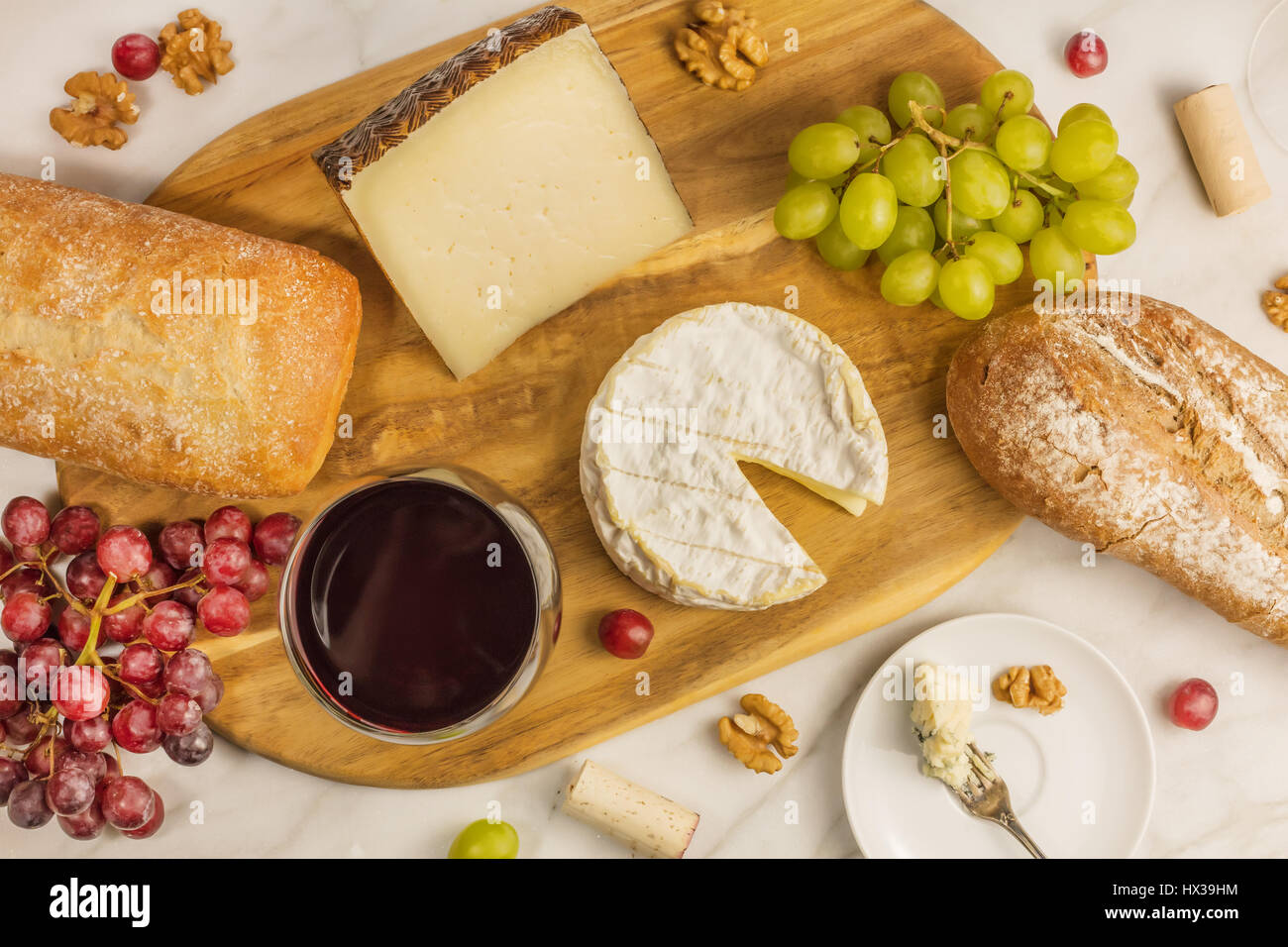 An Overhead Photo Of A Glass Of Red Wine With Cheese White And Rye Bread Purple And Green Grapes And Walnuts At A Wine Pairing Stock Photo Alamy