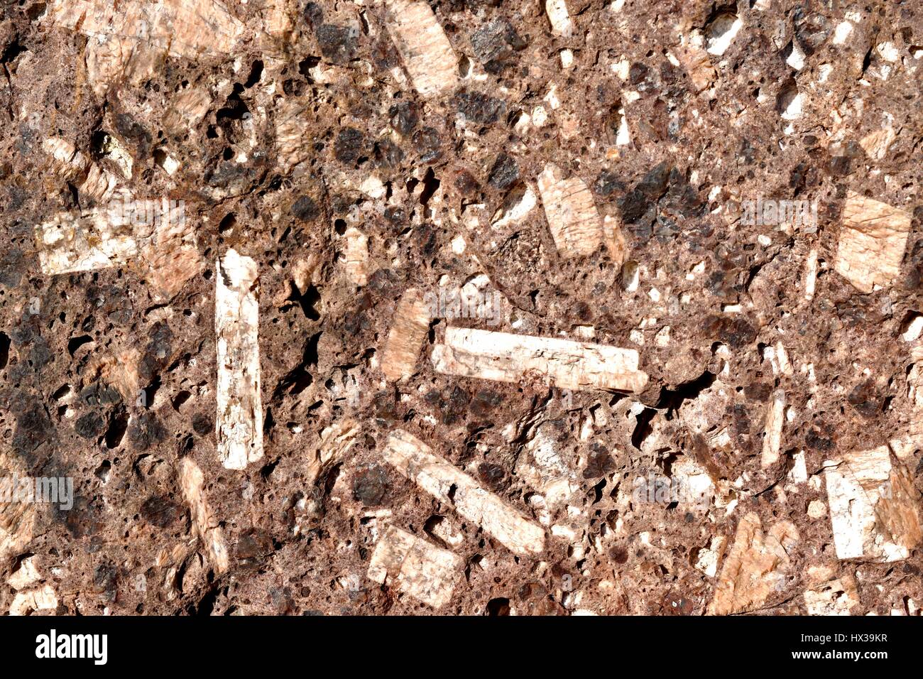 A block of weathered red granite, showing large crystals of feldspar, dark hornblende, light quartz, and mica. Stock Photo