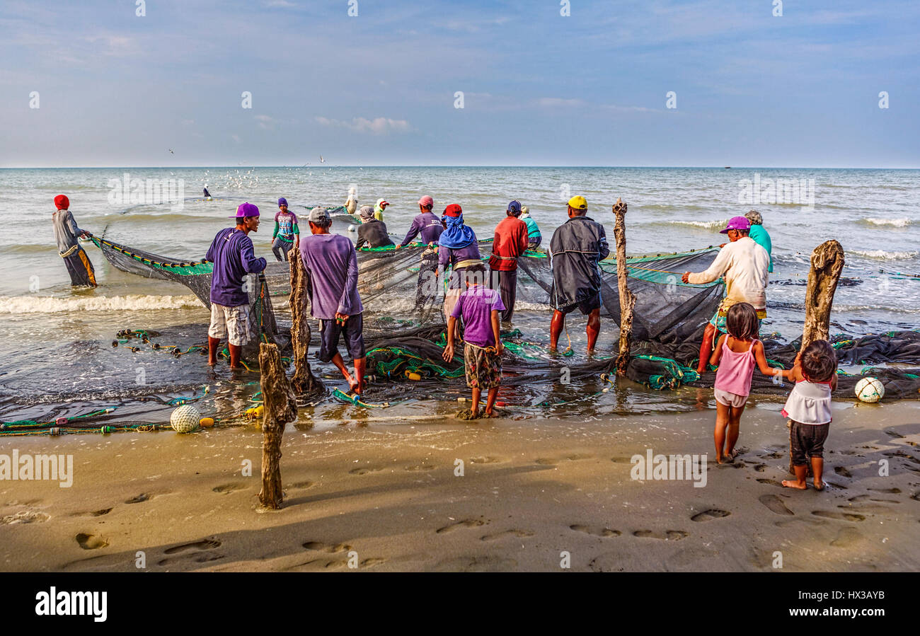 Members of a fishing village at Baybay Beach, Roxas, Capiz, Panay Island, Philippines work together to haul their seine net to shore. Stock Photo
