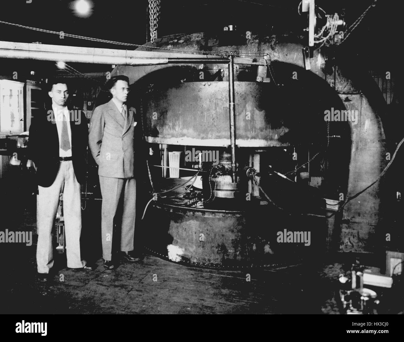 Scientists Ernest O, 1934. Lawrence and M. Stanley Livingston standing in front of the Cyclotron, a particle accelerator that won them a Nobel Prize, Radiation Laboratory, University of California, Berkeley. Stock Photo