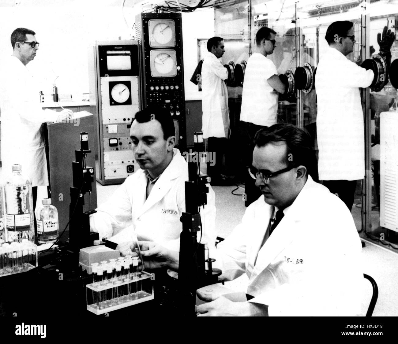 Staff members of the Biophysical Separation Laboratory examine the equipment in the virus isolation facility at Oak Ridge National Laboratory, Oak Ridge, Tennessee, 1965. Image courtesy US Department of Energy. Stock Photo