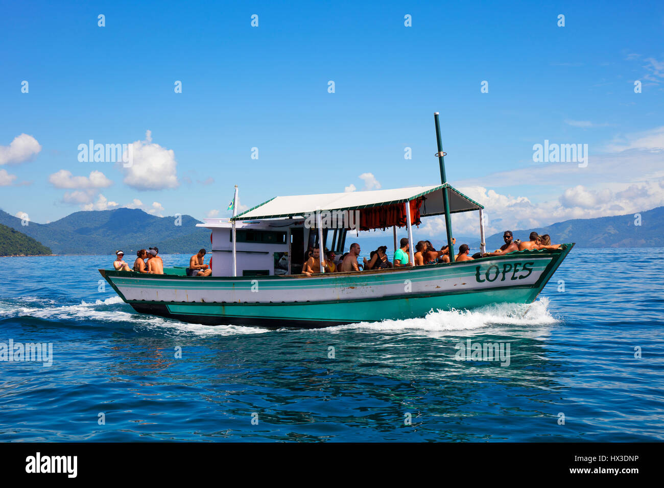 A small boat carrying tourists from Villa do Abraao to the beach of Lopes Mendes. Ilha Grande, RJ, Brazil. Stock Photo