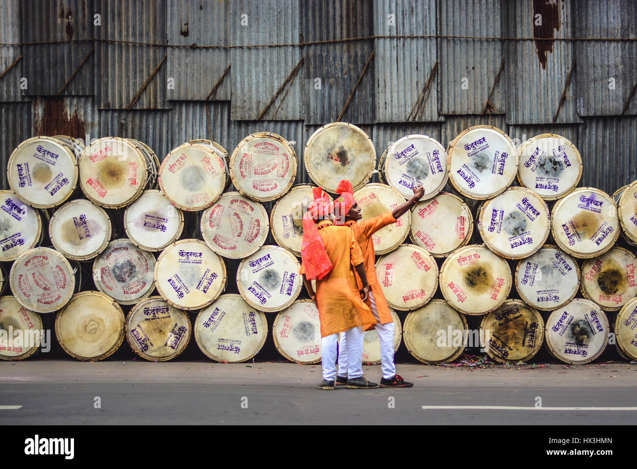 Drummers dressed in traditional indian outfits taking a selfie with large drums in the background (Nasik Dhols) just before the performance. Stock Photo