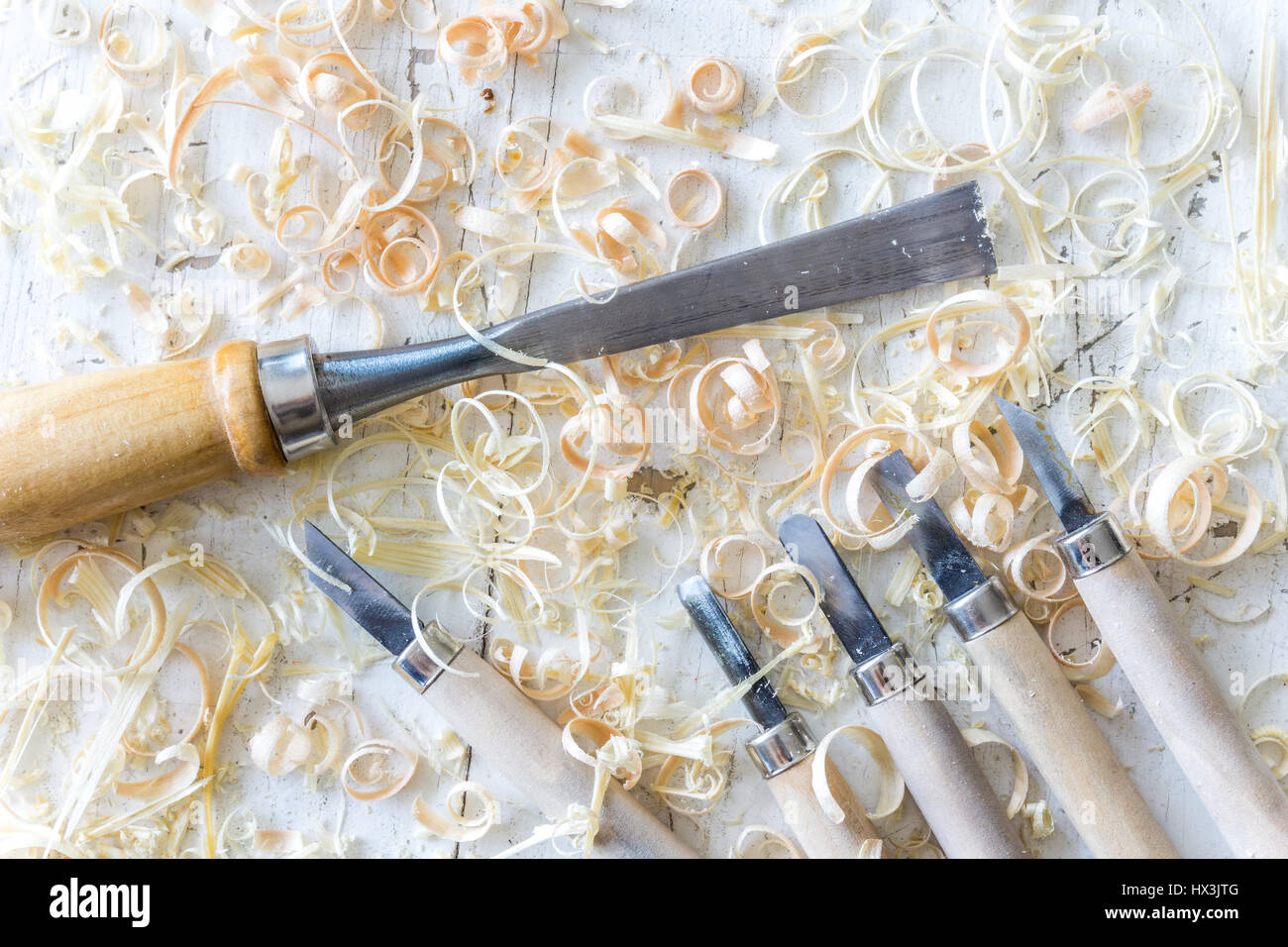 Collection of metal carving hand tools and chisels on a white vintage