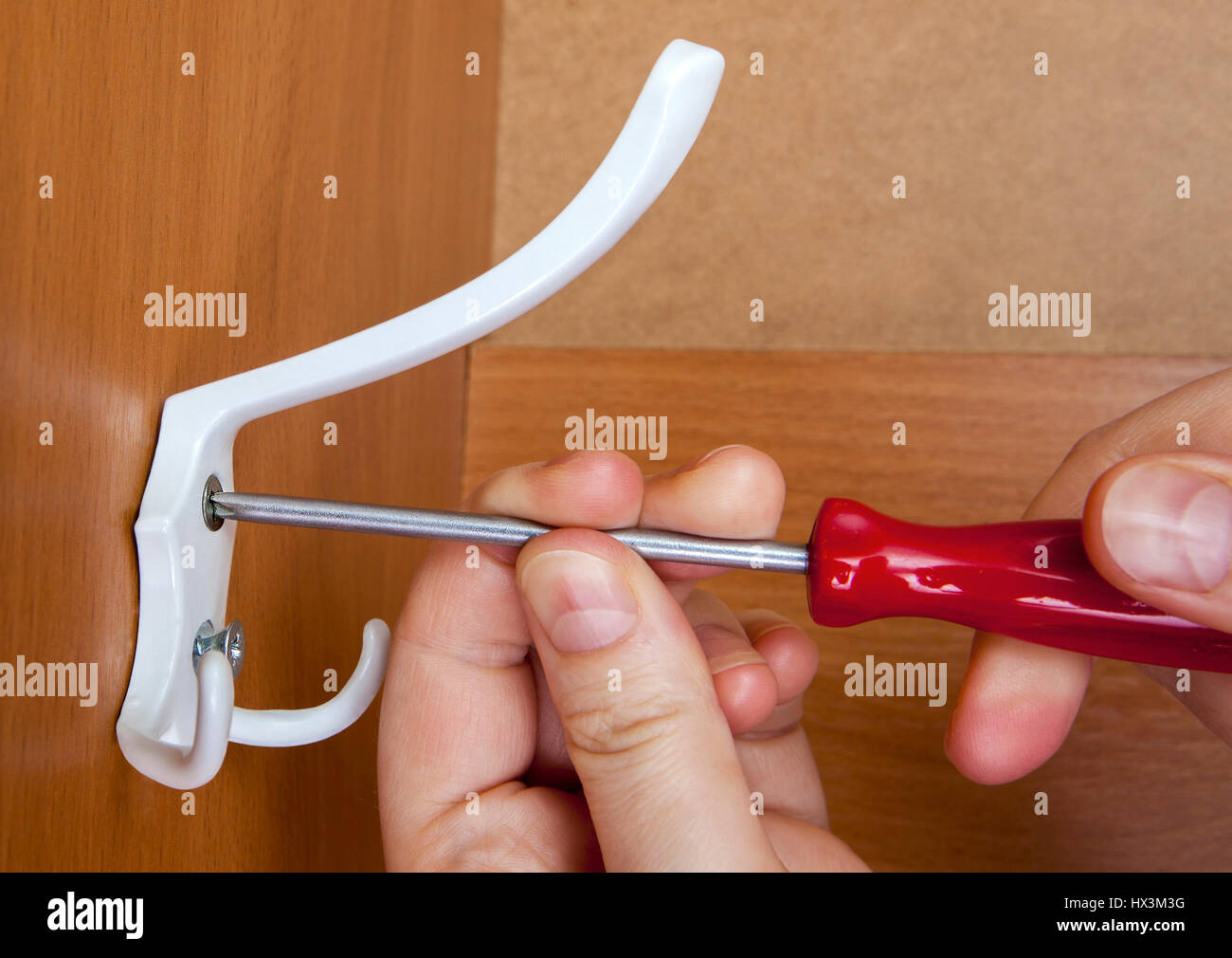 Coat hook mounted by means red screwdriver in locker room Stock Photo