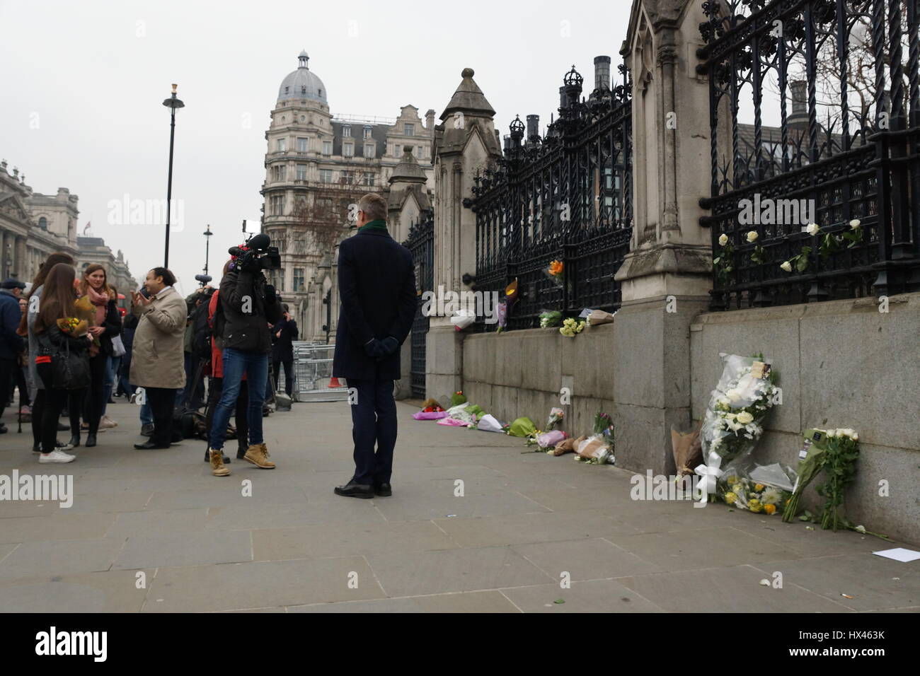 London, UK. 23rd Mar, 2017. A television journalist reports from the scene.The scene outside the Houses of Parliament in the wake of the murder of PC Keith Palmer by Khalid Massood, also known as Adrian Elms, also known as Adrian Russell Ajao on Wednesday 21 March 2017. Members of the public pay floral tribute whilst television journalists make their reports and police officers survey the scene. Credit: Peter Hogan/Alamy Live News Stock Photo