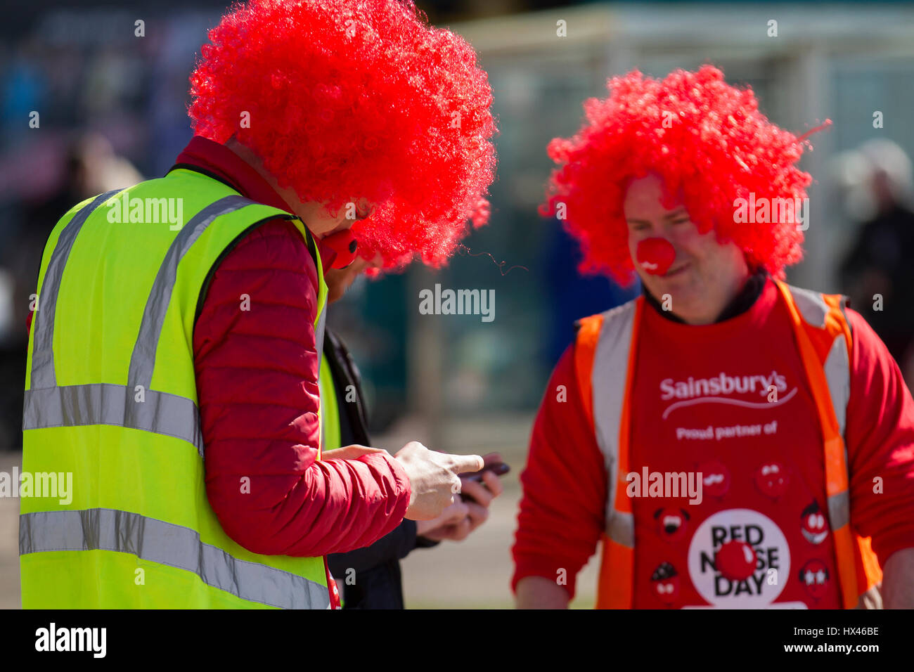 Red Nose Day, as Sainsbury sponsored male fundraisers in red head wigs, enter on an 8 mile walk