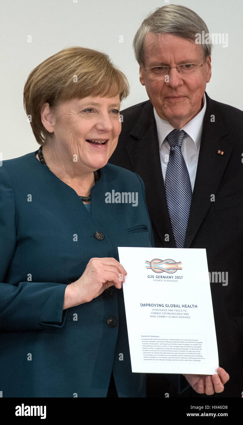 German Chancellor Angela Merkel is presented with a paper by the president of National Academy of Sciences, Leopoldina, Joerg Hacker (R) in Halle (Saale), Germany, 22 March 2017. The German head of government is taking recommendations from international scientists. Under the leadership of the Leopoldina academy, the national science academies of the 20 largest industrial and developing countries (G20) submitted recommendations for improvement of global health provision. Photo: Hendrik Schmidt/dpa-Zentralbild/dpa Stock Photo