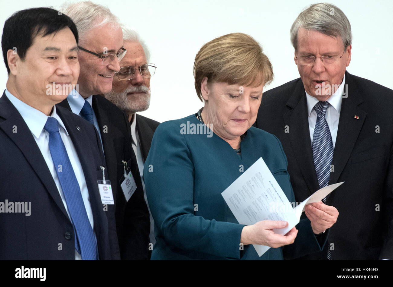 German Chancellor Angela Merkel (2nd from R), accompanied by various academics, is presented with a paper by the president of National Academy of Sciences, Leopoldina, Joerg Hacker (R) in Halle (Saale), Germany, 22 March 2017. The German head of government is taking recommendations from international scientists. Under the leadership of the Leopoldina academy, the national science academies of the 20 largest industrial and developing countries (G20) submitted recommendations for improvement of global health provision. Photo: Hendrik Schmidt/dpa-Zentralbild/dpa Stock Photo