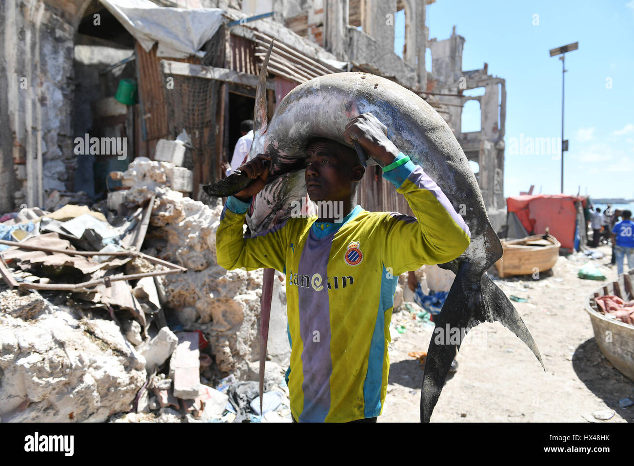 Mogadishu, Somalia. 23rd Mar, 2017. A man carries a sailfish to the ...