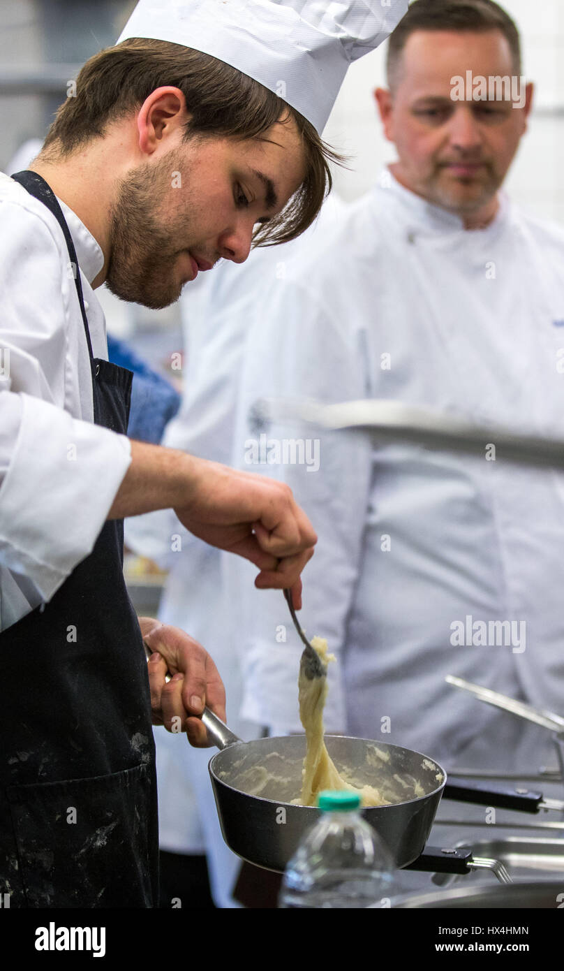 Stralsund, Germany. 21st Mar, 2017. Trainee cook Lorenz Maash from Neustrelitz gets observed while cooking by a jury member during a competition for up and coming chefs in German state of Mecklenburg-Western Pomerania, in Stralsund, Germany, 21 March 2017. In total 27 trainees from the three local Chamber of Commerce districts qualified for the competition. Photo: Jens Büttner/dpa-Zentralbild/dpa/Alamy Live News Stock Photo
