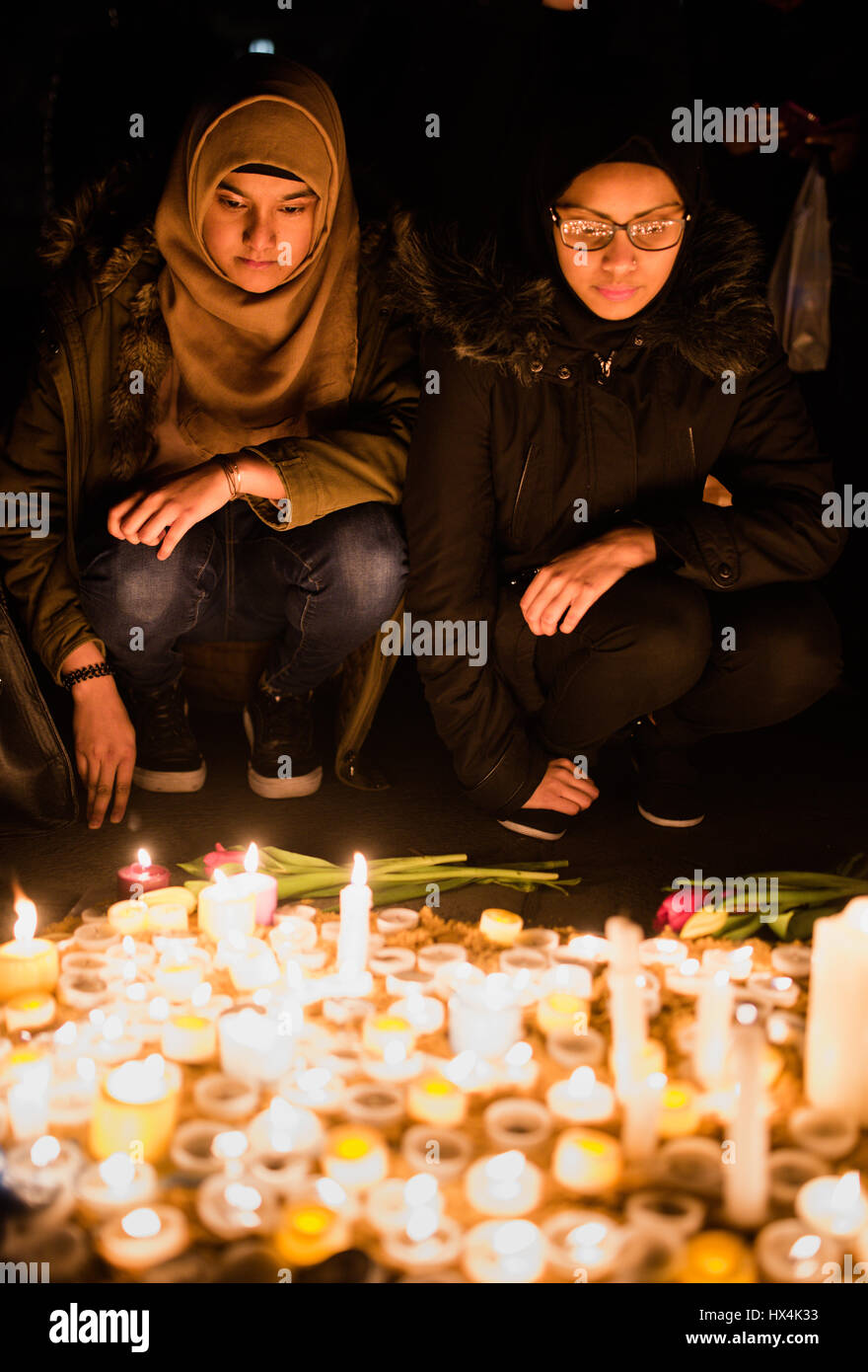 London, UK. 23rd Mar, 2017. Two women light candles in Trafalgar Square, following a vigil to remember the victims of the Westminster terror attack. A crowd of hundreds gathered in the square, lighting candles and listening to speeches. Credit: Jacob Sacks-Jones/Alamy Live News. Stock Photo