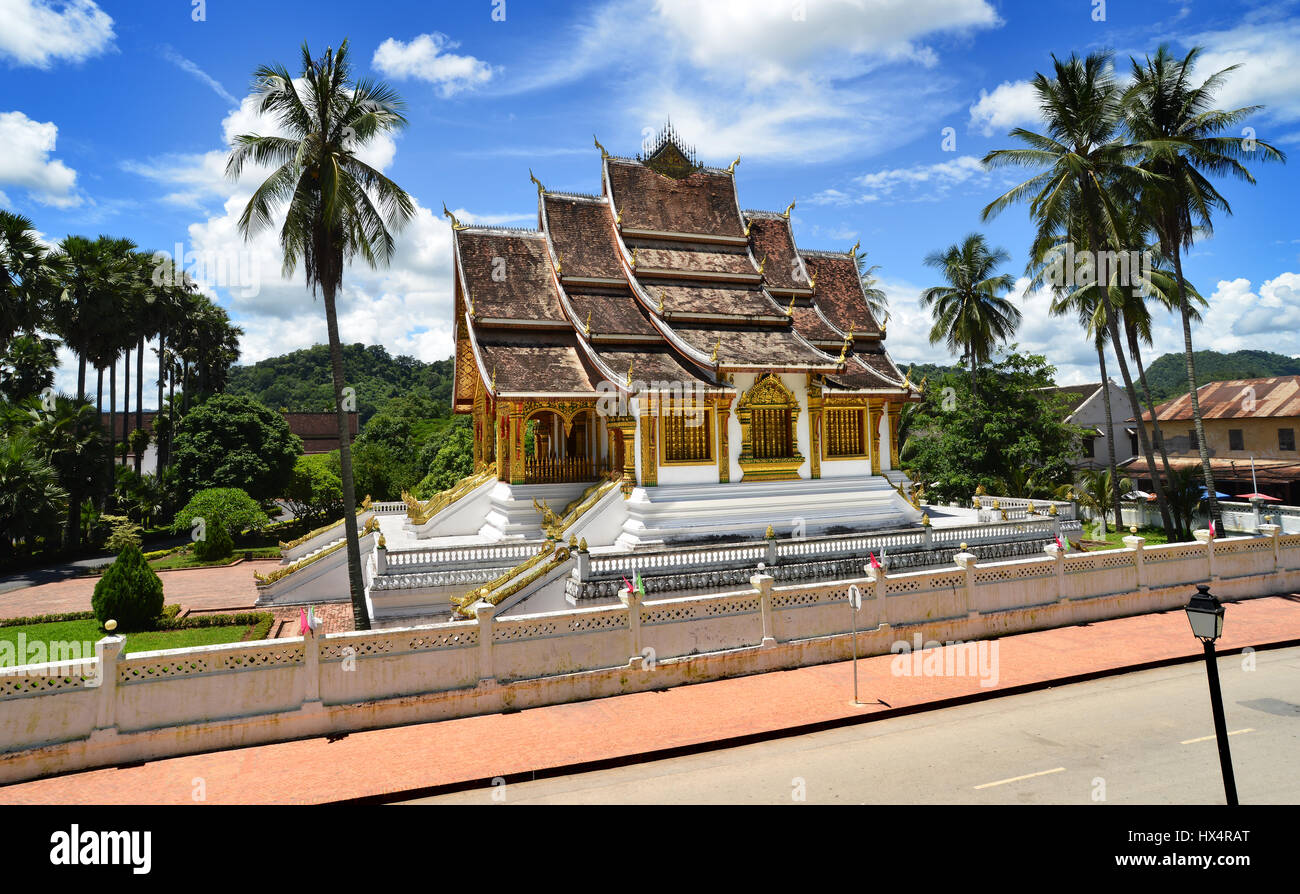 Loungprabang  Laos- August 7, 2015 : Buddhist Temple at Loungprabang royal palace and unfocus of unidentified woman cycling on the main street of the  Stock Photo