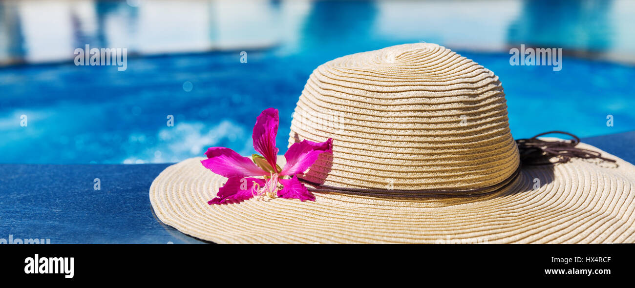 Straw hat with orchid flower near swimming pool - holiday concept Stock ...