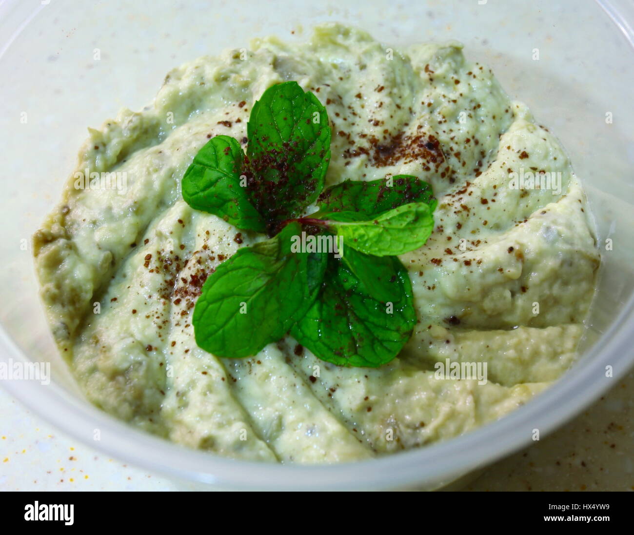 A pot of Lebanese Arab mutabal dip, or baba ganoush,made from tahini and roasted eggplant, topped with a sprig of mint and a sprinkling of sumac Stock Photo