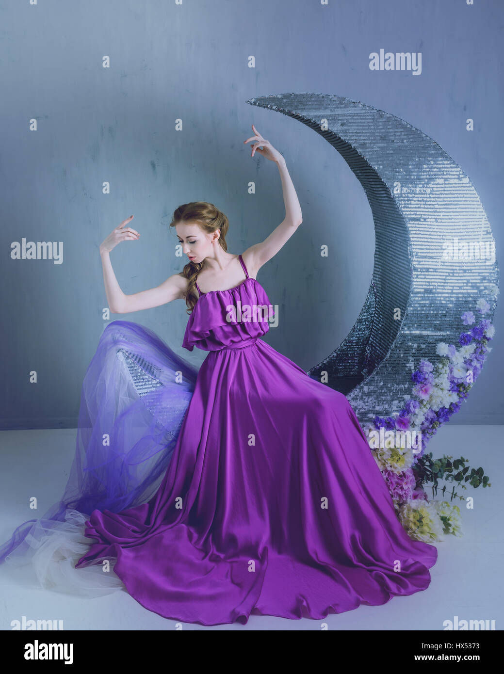 Cute girl dancer in a beautiful dress posing in the studio. Tinted ...