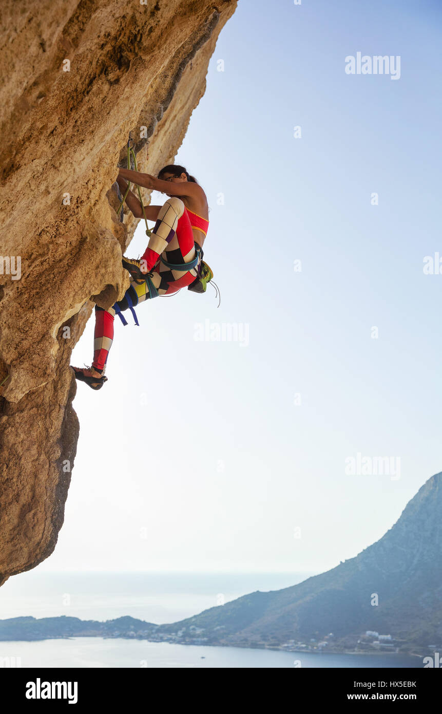Young woman struggling to climb challenging route on cliff, Kalymnos island, Greece Stock Photo