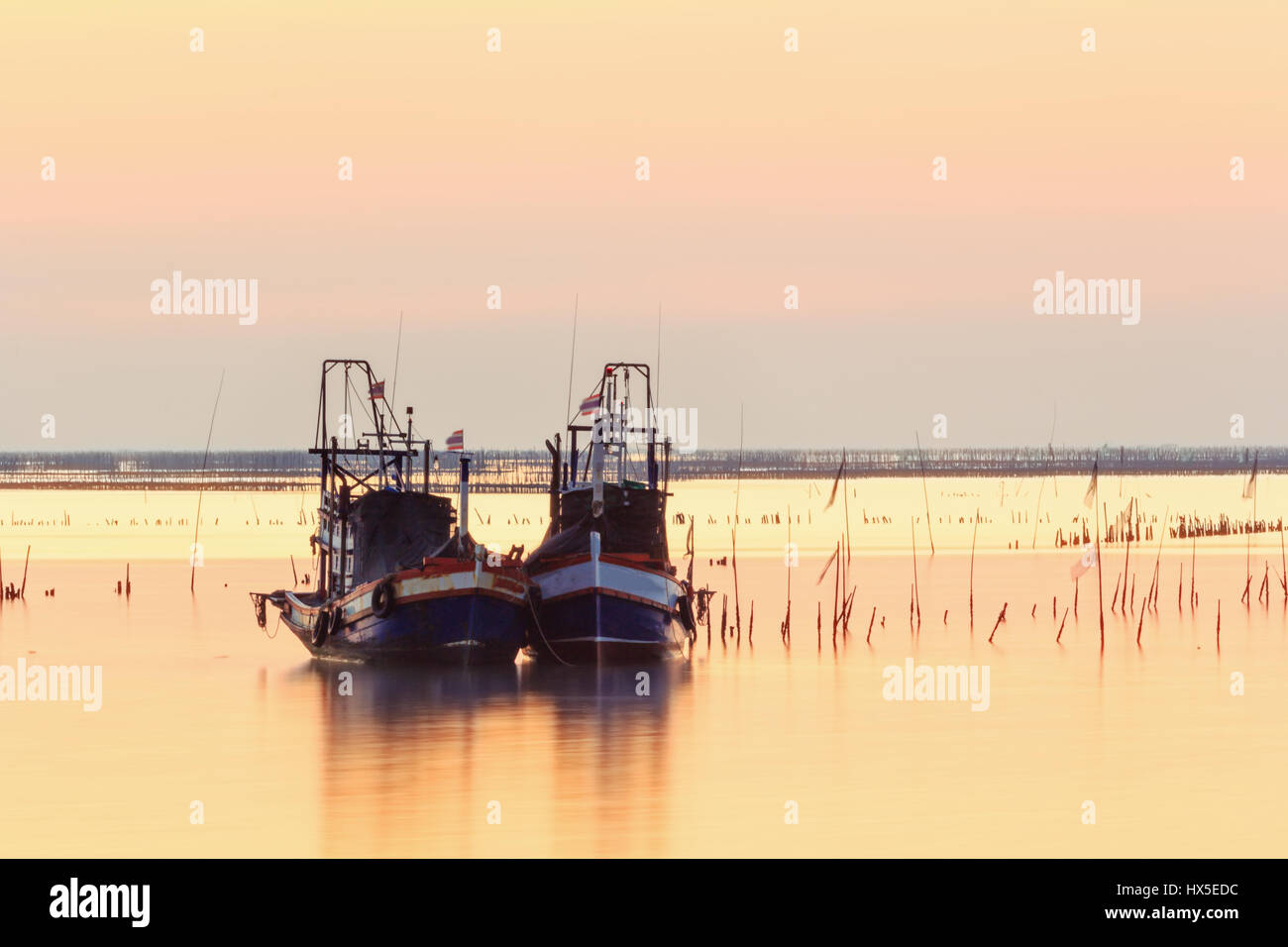 Small fishing boats used as a vehicle for finding fish in the sea.at sunset Stock Photo