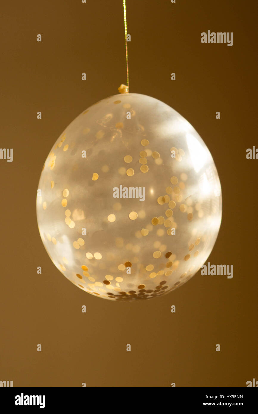 A confetti balloon in gold tones Stock Photo