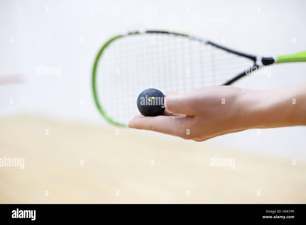 squash racket and ball in man's hands. Racquetball equipment. Photo with selective focus. Player