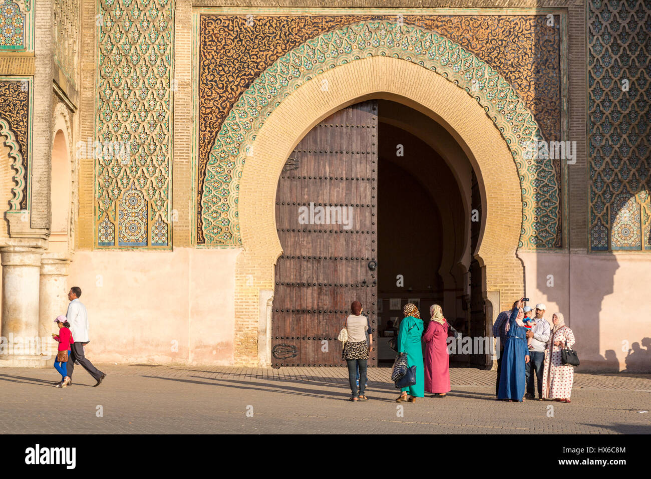 Meknes, Morocco.  People in front of the Bab Mansour, built 1672-1732; Moroccan Family on right taking a selfie. Stock Photo
