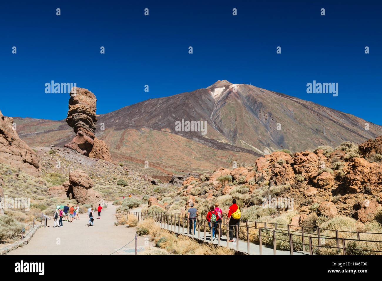 TENERIFE - OCTOBER 10: Tourists walking towards Roque Cinchado in Tenerife, Spain, with the Pico del Teide in the background on October 10, 2014 Stock Photo