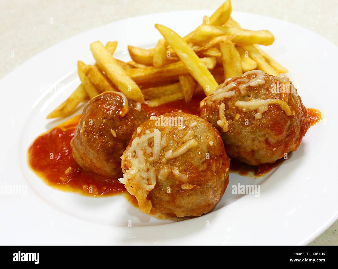 Meatballs with tomato sauce and french fried potato chips angled, Stock Photo