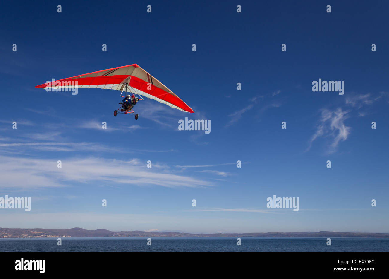 an hang glider flying over Bracciano lak,e, near Rome, italy in a very clear, sunny day Stock Photo