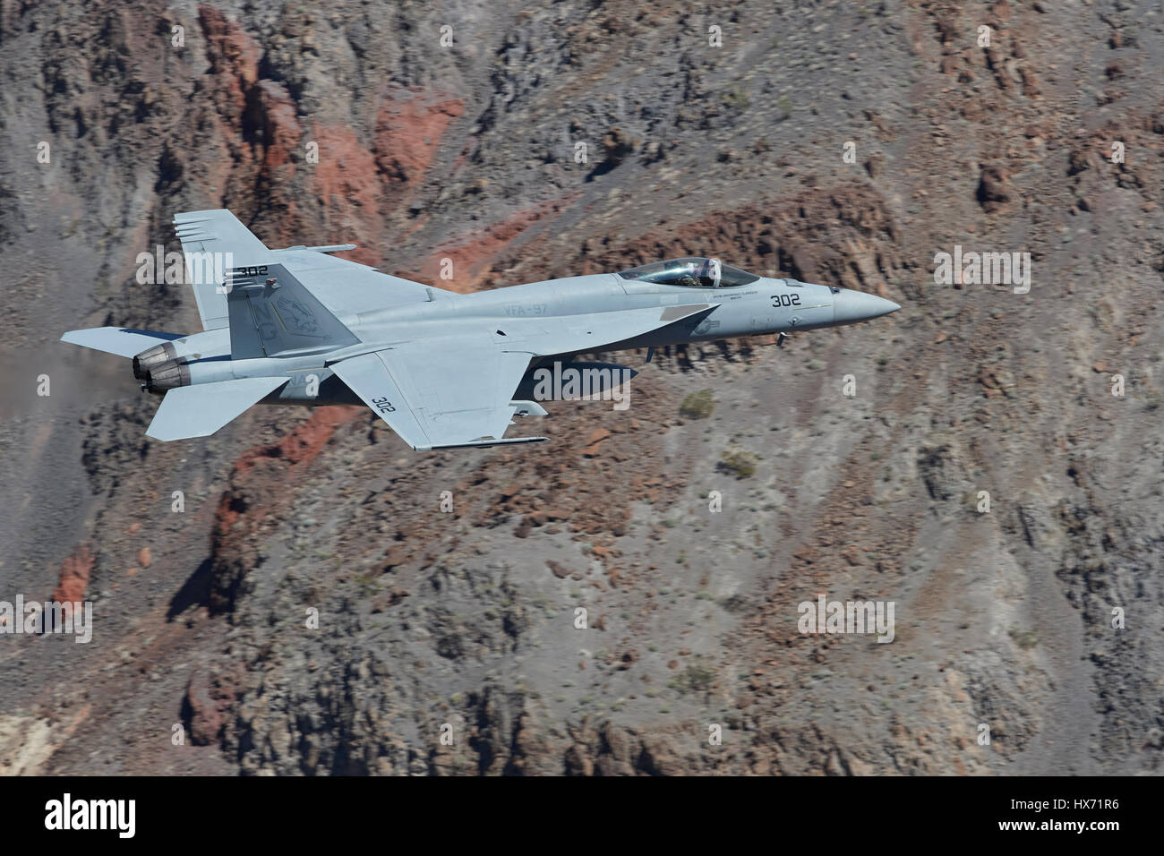 United States Navy F/A-18 Super Hornet Flying At Low Level Through A Desert Canyon. Stock Photo
