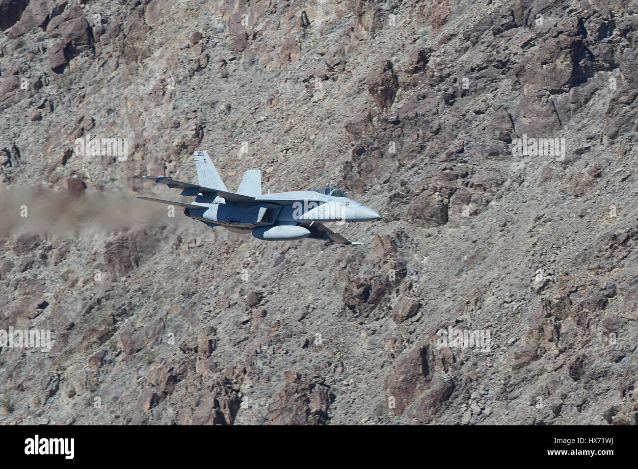 United States Navy F/A-18E Super Hornet Flying At Low Level Through A Desert Canyon. Stock Photo