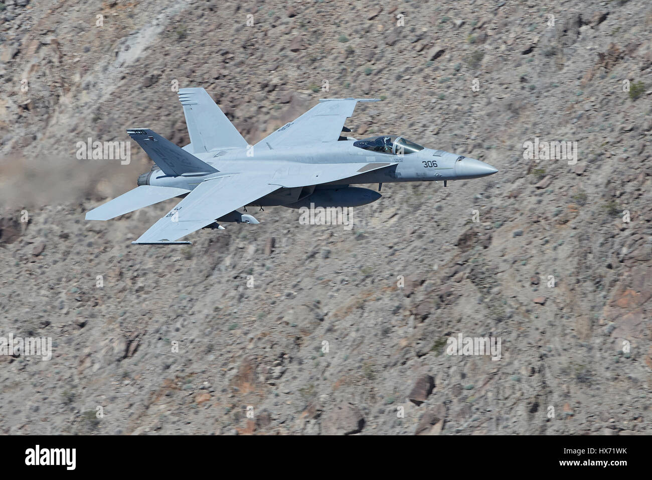 United States Navy F/A-18E Super Hornet Flying At Low Level Through A Desert Canyon. Stock Photo