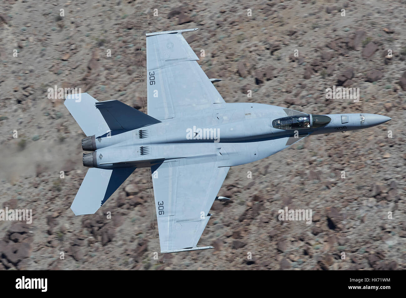 United States Navy F/A-18E Super Hornet Flying At Low Level Through A Desert Canyon. Stock Photo