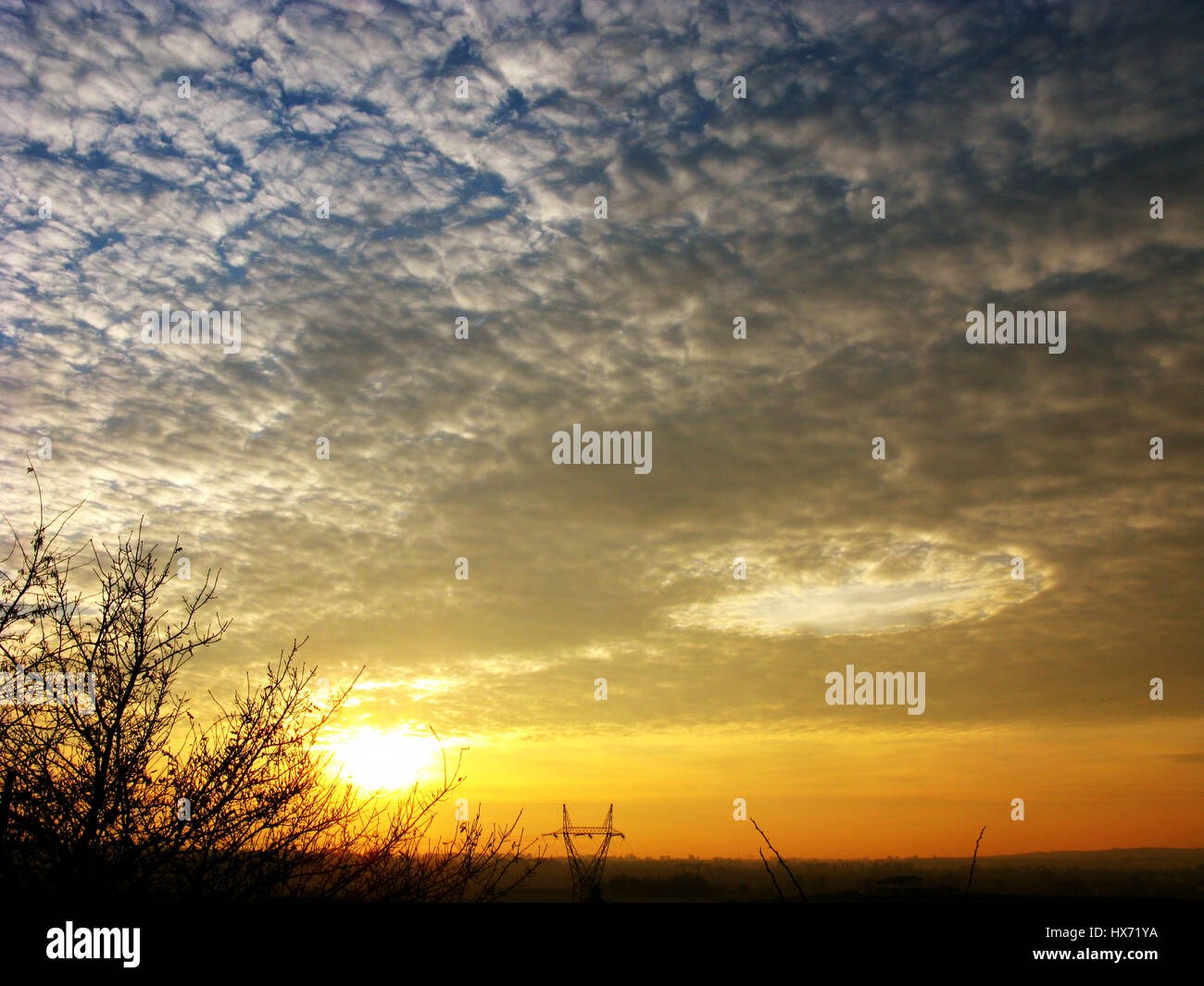 A singular cloud formation in a mackerel sky at sunset Stock Photo
