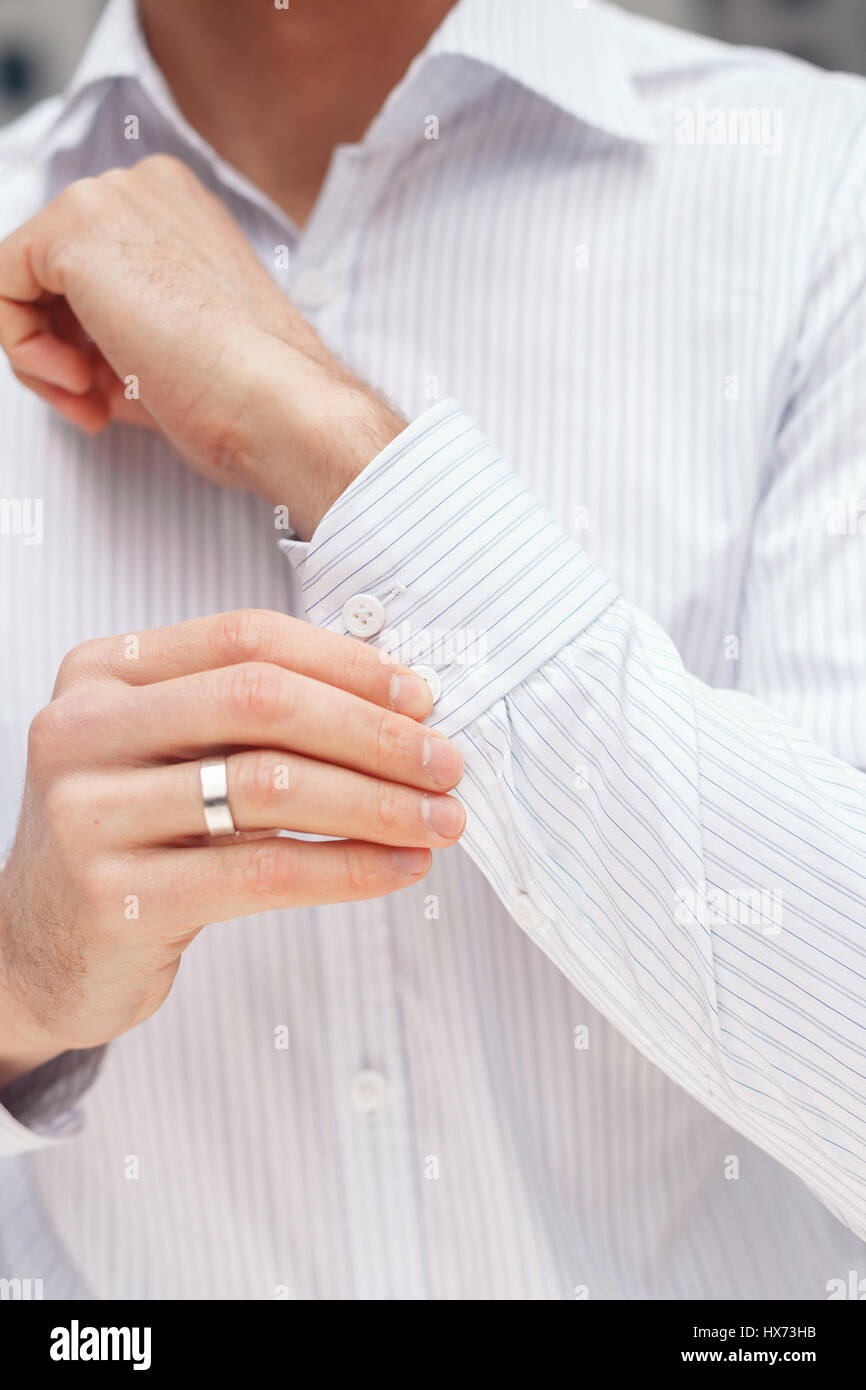 Man buttons cufflink on French cuffs sleeves Stock Photo Alamy