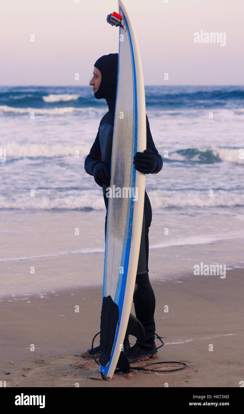 Surfboard with attached action camera standing on the sand on the beach. Stock Photo