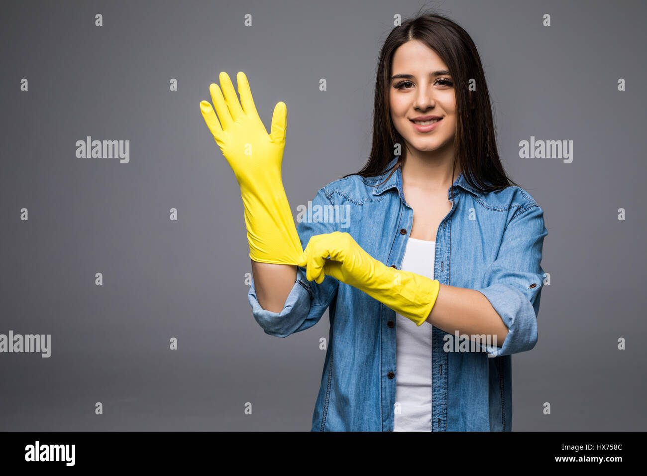 Cleaning lady getting spring cleaning ready putting on rubber gloves ...