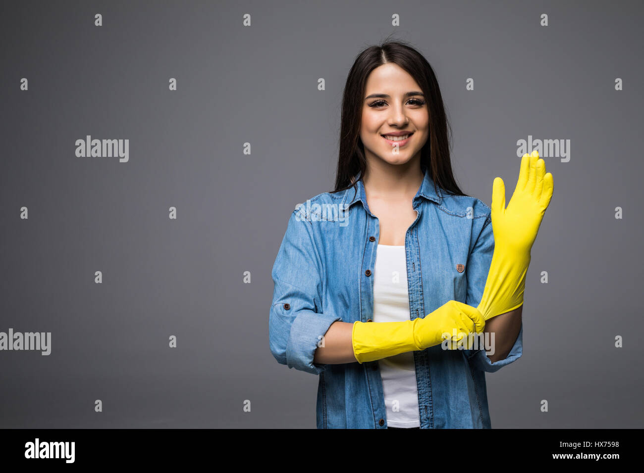 Cleaning lady getting spring cleaning ready putting on rubber gloves ...