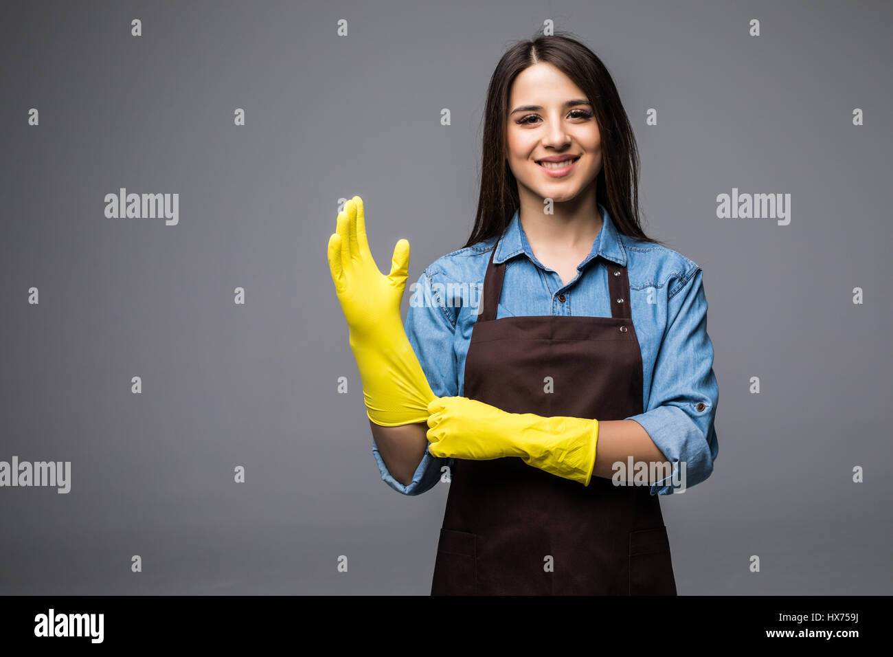 Cleaning lady getting spring cleaning ready putting on rubber gloves ...