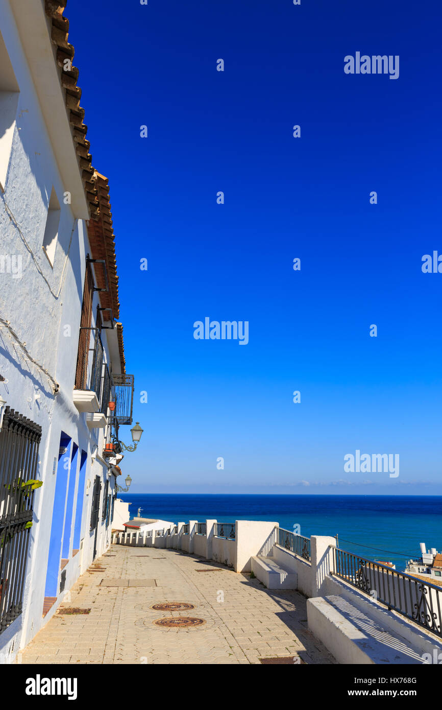 View along a traditional whitewashed Spanish houses towards the Mediterranean Sea in Sella Old Town, Costa Blanca, Spain Stock Photo