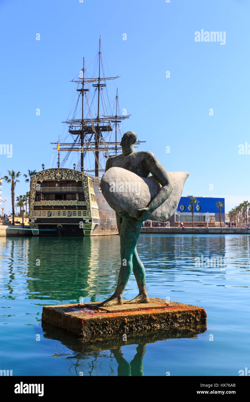 Statue of Icarus with the replica of  Spanish ship Santisima Trinidad in the background, Alicante Harbour, Costa Blanca, Spain Stock Photo