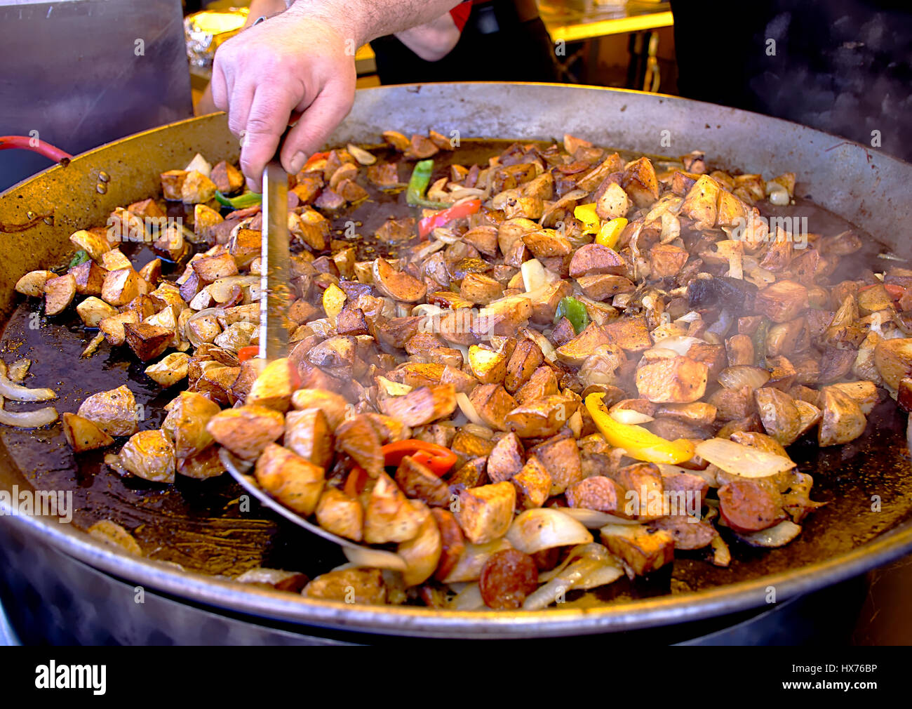 Chef hand cooking Spanish food meal on big pan on street market in